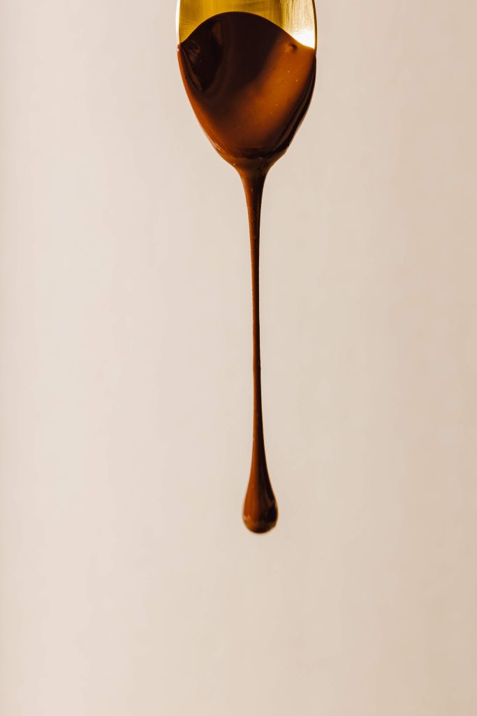 Dieses Bild zeigt einen Löffel, von dem Schokolade herunter tropft.
